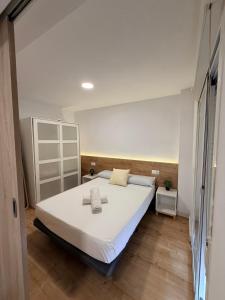 une chambre avec un grand lit avec des draps blancs dans l'établissement Pescadors Apartamentos TRG, à Benidorm