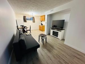 a living room with a couch and a television at Oscar's Retreat - 1Bedroom Apart in Moncton