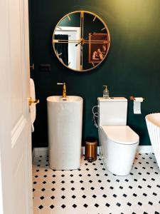a bathroom with a white toilet and a mirror at Willow32 Chalet in Bran +54 photos