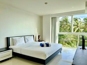 a bedroom with a bed and a large window at Sunset Plaza by RESAVA in Karon Beach