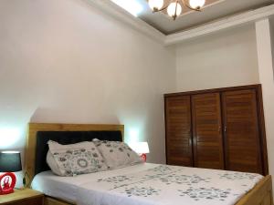 une chambre avec un lit et une armoire en bois dans l'établissement Grand Appartement à essos mobile, à Yaoundé 12 autres photos
