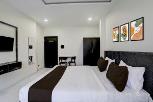 Un dormitorio con una cama grande y un televisor. en Hotel O Laxmi Lodging, en Aurangabad