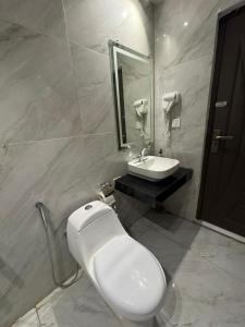 a bathroom with a toilet and a sink at Cozy & Peaceful Rooms Near Lyallpur Galleria in Faisalabad +8 photos