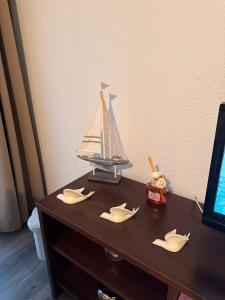 un bateau à jouets assis au-dessus d'une table en bois dans l'établissement L,orchidée, à Équemauville 3 autres photos