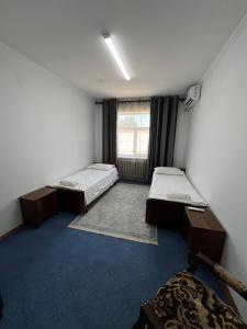 a room with two beds and a window at Гостевой дом Энесай in Bishkek