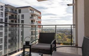a balcony with a chair and a view of the city at Joy City Stay Forest 54-85 in Dumbrăviţa