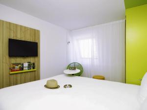 ein Zimmer mit einem Bett und einem Flachbildfernseher in der Unterkunft Ibis Styles Toulouse Labège in Labège + 110 Fotos