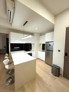 a kitchen with white cabinets and a white counter top at KLCC Star Residences by Nexus 11 in Kuala Lumpur