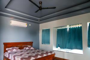 a bedroom with a ceiling fan and a bed at SPK farmhouse in Medchal +7 photos