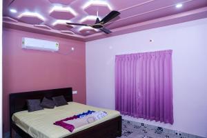 a bedroom with a bed with a ceiling fan at SPK farmhouse in Medchal