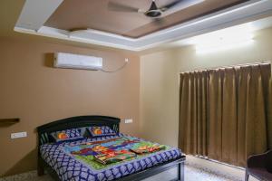 a bedroom with a bed and a ceiling fan at SPK farmhouse in Medchal