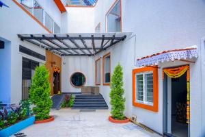 an entrance to a white building with trees in front at SPK farmhouse in Medchal