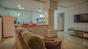 un soggiorno con un divano e una TV di Vila Fox Suites com Varanda a Lençóis