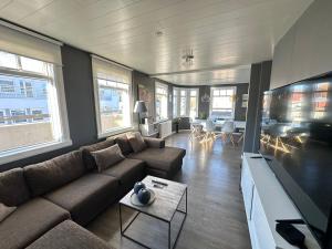 un salon avec un canapé et une télévision à écran plat dans l'établissement Penthouse apartment in Downtown Akureyri - Birta Rentals, à Akureyri