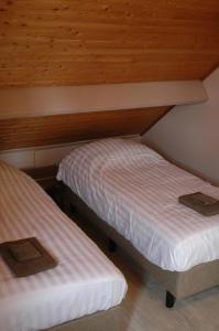 two beds in a room with wooden ceilings at Holiday Home near town in Aarschot