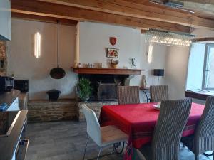 Un comedor con mesa y sillas y chimenea. en Maison de caractère au cœur des grands causses, en Viala-du-Tarn