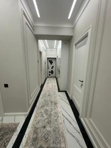een hal met witte muren en een tapijt bij Prime House Samarkand 2 in Samarkand