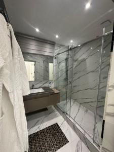 een badkamer met een wastafel en een glazen douche bij Prime House Samarkand 2 in Samarkand