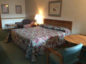a hotel room with a bed and a table at The Royal Inn in Ridgway