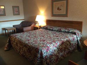 a hotel room with a bed and a chair at The Royal Inn in Ridgway