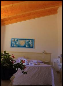 a bedroom with a bed with a blue picture on the wall at Il Melograno di Nora in Pula
