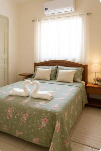 um quarto com duas toalhas de cisne numa cama em Exclusive Seasonal House for COP 30 Luxury for groups of 6 people em Belém