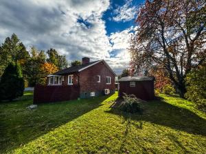 an old brick house on a grassy field at FoRest House in Rosenfors