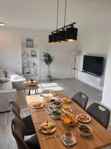 una mesa con comida en la sala de estar en Hyggeapartment Gailingen - Dein Rückzugsort am Hochrhein, en Gailingen