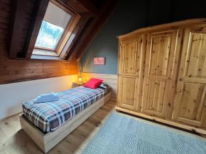 a bedroom with a bed and a large wooden cabinet at Melodia del bosco in Tarvisio