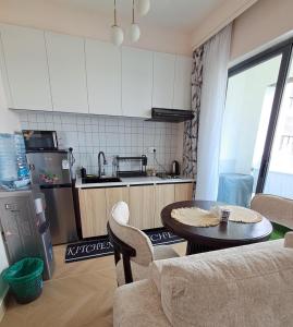 a living room with a table and a kitchen at Reily Luxury Homes - Studio Apartment, Syokimau near JKIA & SGR, PARK VIEW in Nairobi