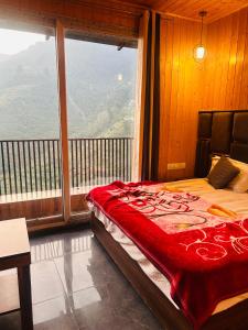 a bedroom with a bed with a large window at 3 H Homestay in Mussoorie