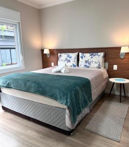 a bedroom with a large bed and a window at Apartamento acolhedor ideal para um casal in Canela