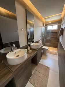 une salle de bain avec deux lavabos et un grand miroir dans l'établissement Apartamento aconchegante na Serra de São Bento, à Serra de São Bento
