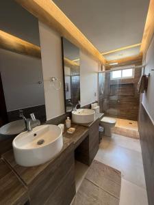 une salle de bain avec deux lavabos et un grand miroir dans l'établissement Apartamento aconchegante na Serra de São Bento, à Serra de São Bento