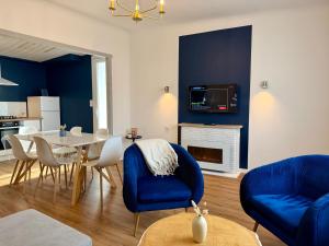 a living room with a table and chairs and a kitchen at L'Abalone 3 Étoiles in Aizenay