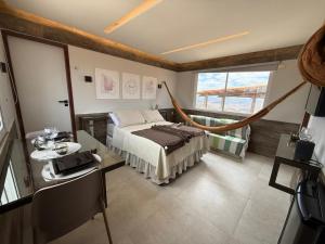 une chambre avec un lit, une table et une fenêtre dans l'établissement Apartamento aconchegante na Serra de São Bento, à Serra de São Bento