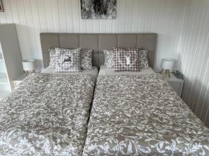 a bed with a gray and white comforter and pillows at Ruhiges Apartment in Weissach - Nähe Porsche in Weissach