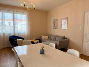a living room with a table and a couch at L'Abalone 3 Étoiles in Aizenay