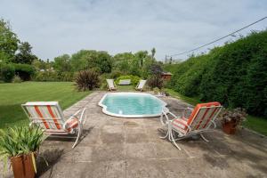 2 Stühle und ein Pool im Hof in der Unterkunft Casa de Campo Duggan - San Antonio de Areco in Duggan
