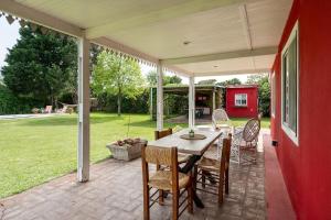 eine Terrasse mit einem Tisch und Stühlen darauf in der Unterkunft Casa de Campo Duggan - San Antonio de Areco in Duggan