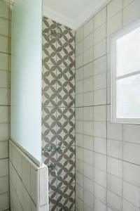 ein Bad mit einer gefliesten Dusche und einem Fenster in der Unterkunft Casa de Campo Duggan - San Antonio de Areco in Duggan
