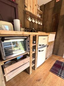 eine Küche mit einer Theke, einer Mikrowelle und einem Kühlschrank in der Unterkunft Country Cottage and Converted Barn Suite in Cholderton