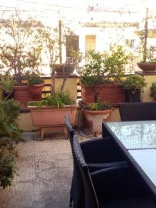 un patio con tavoli, sedie e piante in vaso di bed and breakfast La Terrazza a Genova