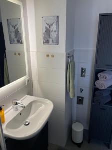 a white bathroom with a sink and a mirror at Ruhiges Apartment in Weissach - Nähe Porsche in Weissach