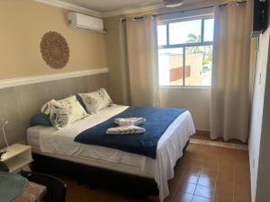 una camera da letto con un letto con asciugamani sopra di SUITES VISTA MAR AZUL a Saquarema