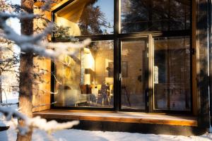 サーリセルカにあるAinur Villasの雪中のガラス引き戸付きの家