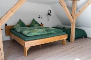 a bed with green sheets and pillows in a room at Kiefer -Ferienwohnung in Dötlingen mit Waldblick in Dötlingen