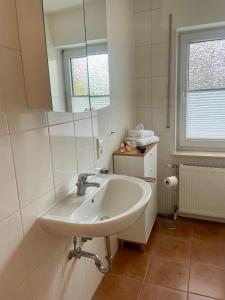 a white bathroom with a sink and a mirror at Your home away from home in Osnabrück