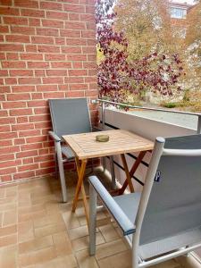 a table and chairs on a balcony with a brick wall at Your home away from home in Osnabrück +13 photos