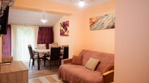 a living room with a couch and a table at Tavasz apartman in Balatonfenyves